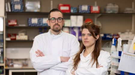 Two researchers standing standing next to each other with their arms crossed