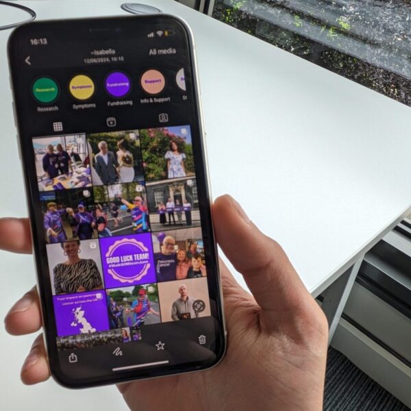 Someone holding a phone with a social media profile open