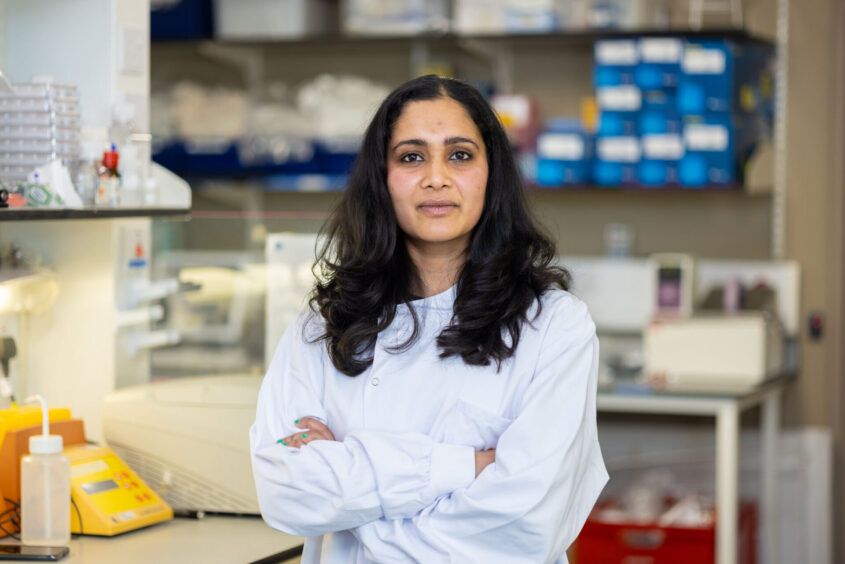 Our researcher, Dr Shalini Rao, standing in a lab looking to camera