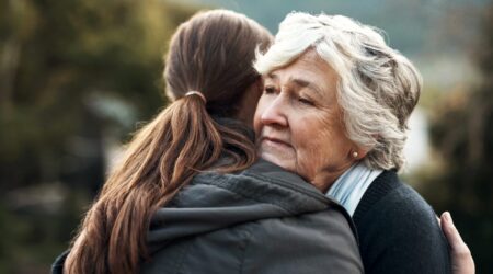 An older woman hugging a younger woman