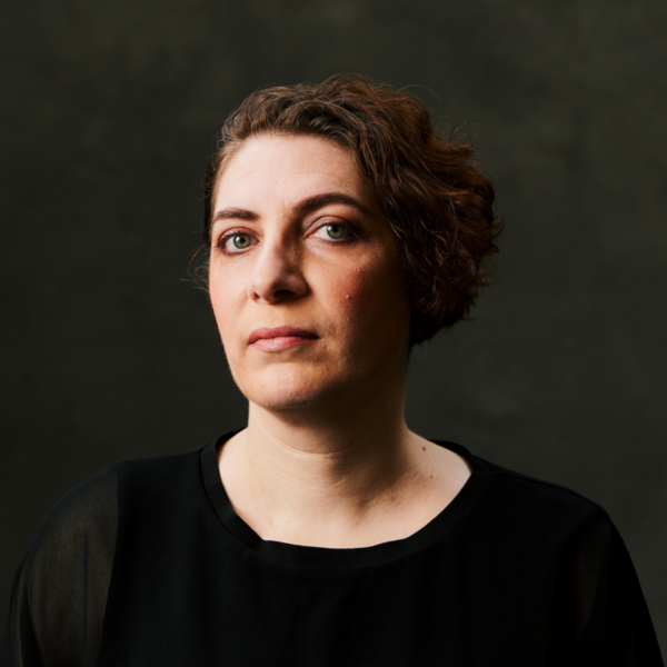 A woman on a black background staring at the camera