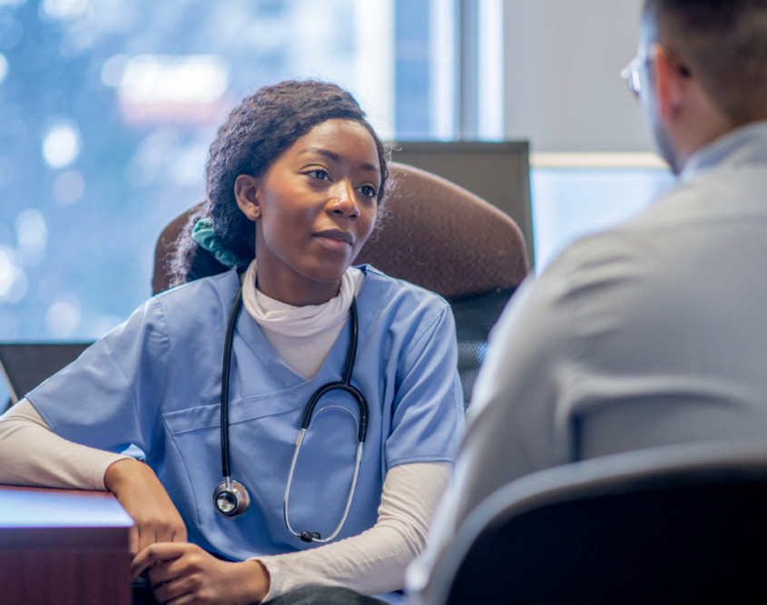 Doctor in scrubs listening to patient talk