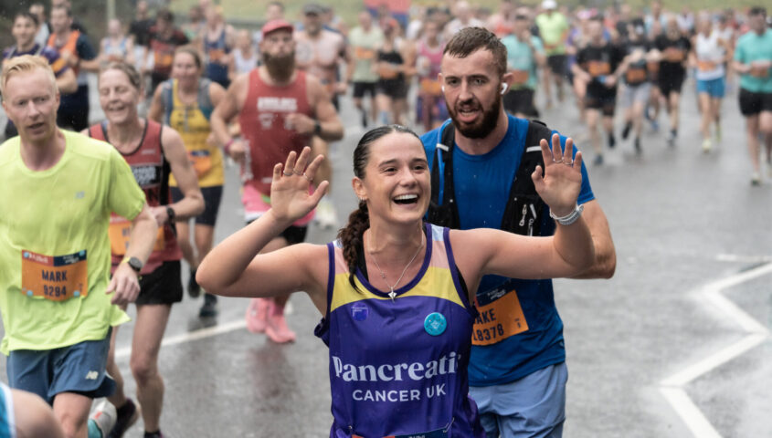 Runner in a Pancreatic Cancer UK vest waving