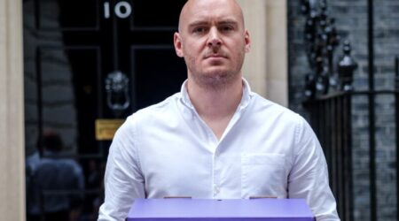 Lewis outside Numer-10 Downing Street Demand Survival Now campaign
