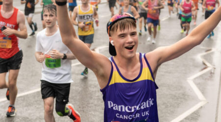 Runner in Pancreatic Cancer UK vest running with arms up