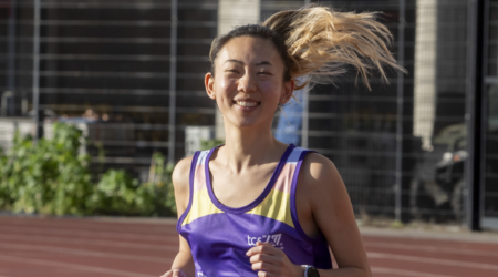 Claire running on a track in a Pancreatic Cancer UK running vest
