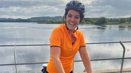 Young woman on a bike in front of a stretch of water