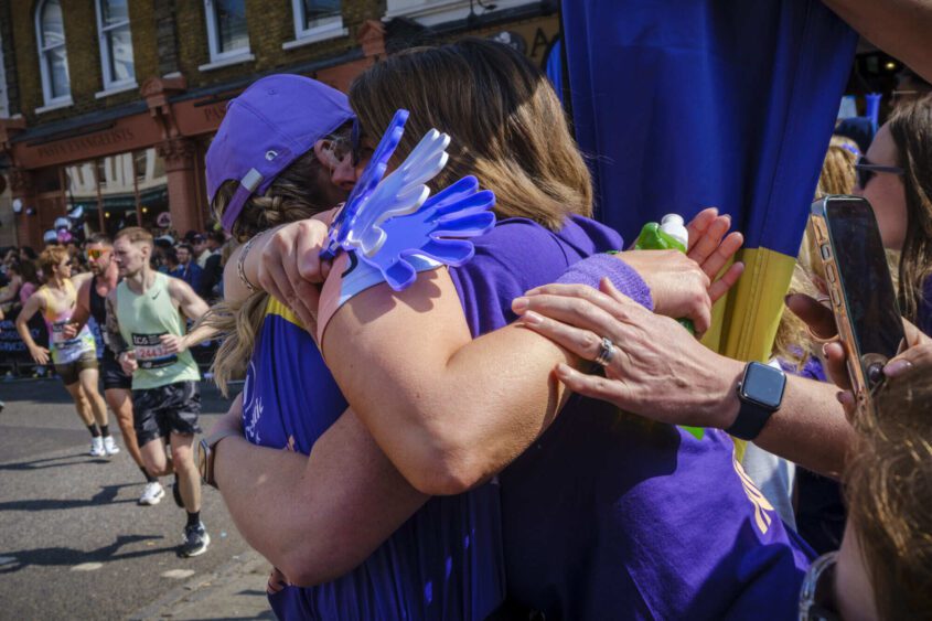 A PCUK supporter hugging a runner at the London Marathon