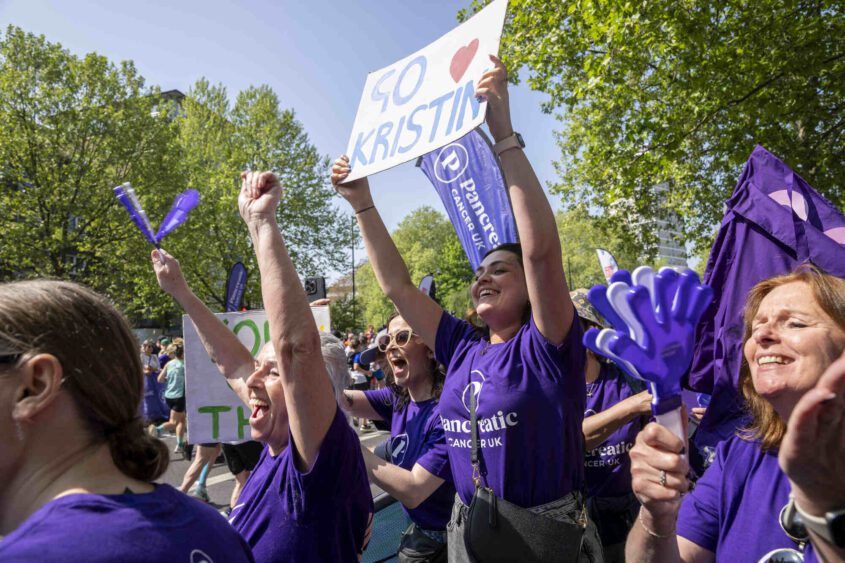 Supporters wearing purple PCUK t-shirts and holding a sign that reads 'Go Kristin'