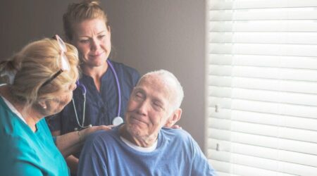 A person being supported by health care professionals at home