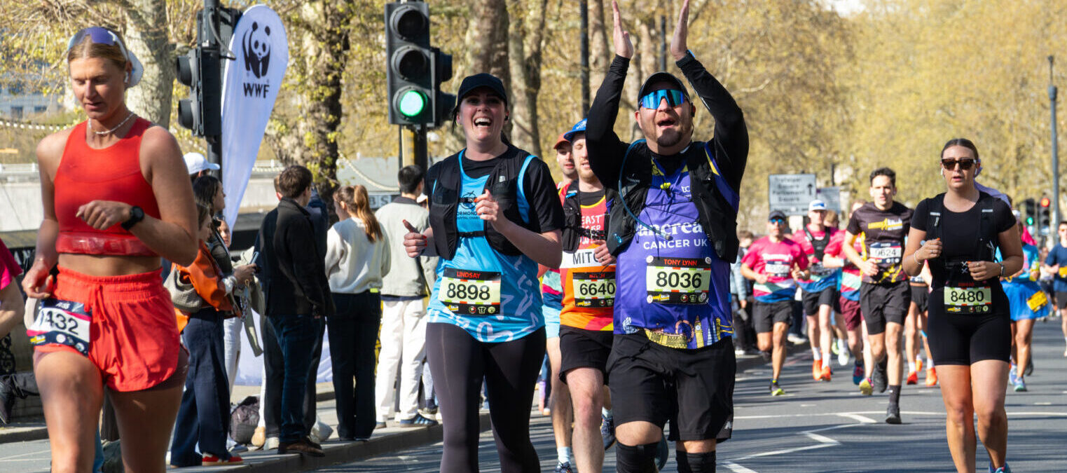 Man running clapping his hands together wearing a pancreatic cancer running top