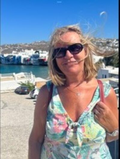 Volunteer Karen standing at a beach resort, smiling at the camera