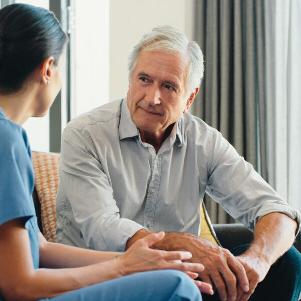 Elderly man being spoken to by a nurse