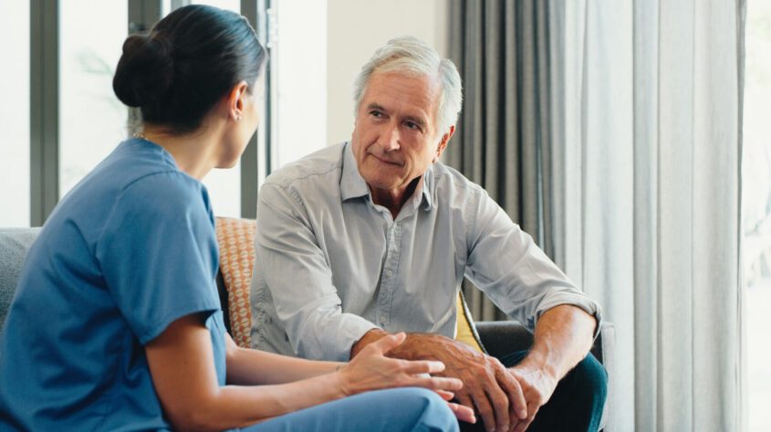 Elderly man being spoken to by a nurse