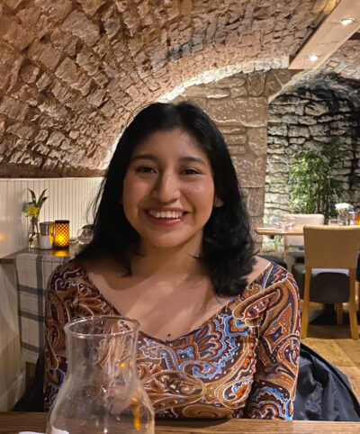 Young woman sitting in restaurant smiling to camera