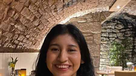 Young woman sitting in restaurant smiling to camera