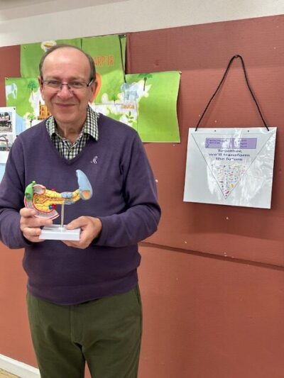 Mark, a lived experience participant, standing next to a wall with posters