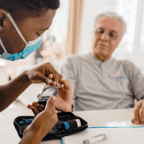 A health professional measuring the blood glucose level of a patient