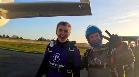two people heading towards a plane ready for a skydive wearing a pancreatic cancer top