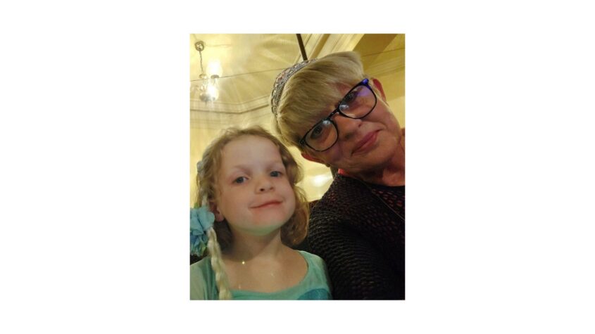 Middle aged lady and young child both looking to camera