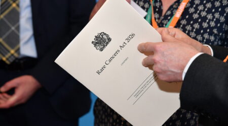Hands holding the Rare Cancer bill 2026