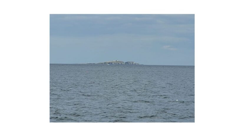 An island in the distance of a grey sea