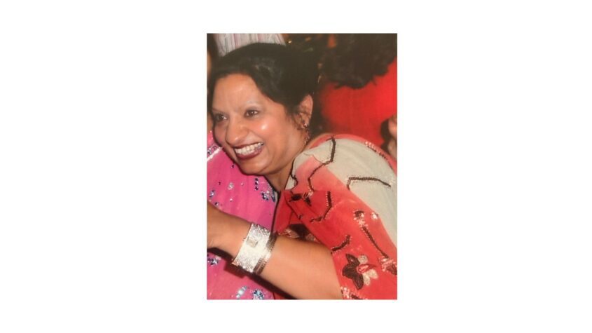 woman wearing red and white top with sequins, smiling broadly