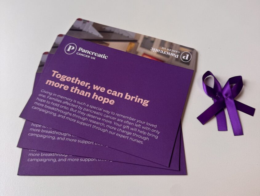 Memorial donation envelopes and purple ribbon pins