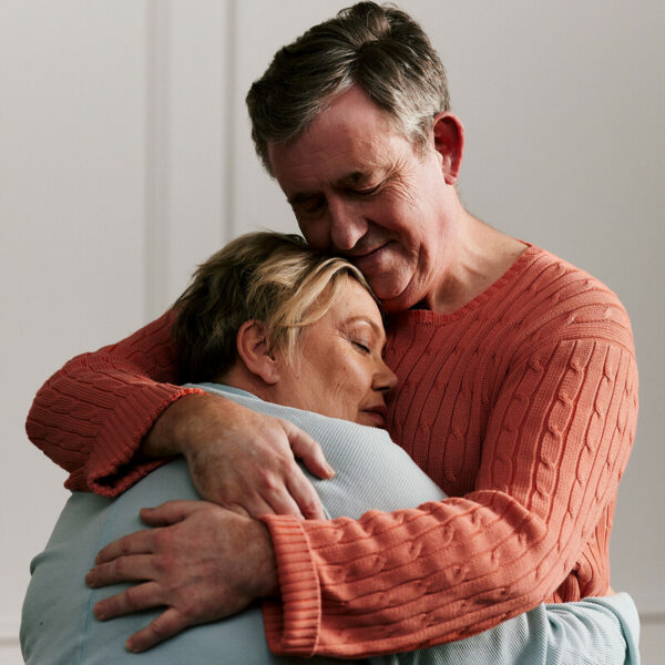 Couple affected by pancreatic cancer hugging one another.
