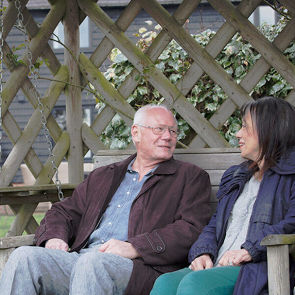 Man and woman sitting on a bench talking outside