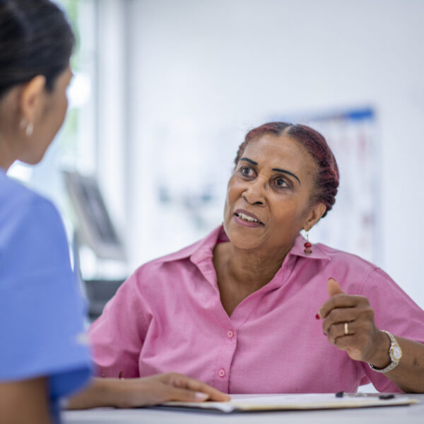 Senior citizen at doctor's office with caring medical professional.