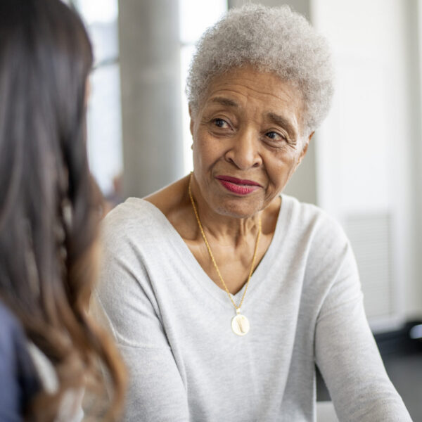 Medical professional meets with patient at long term care facility or home setting.