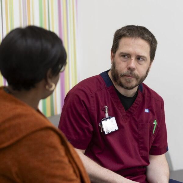 Male nurse supports female patients in hospital setting