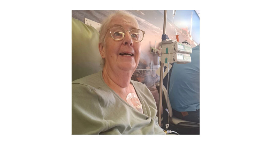 older lady sitting in a hospital chair with medical equipment behind her